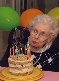 ELDERLY WOMAN BLOWING OUT CANDLES CARD
